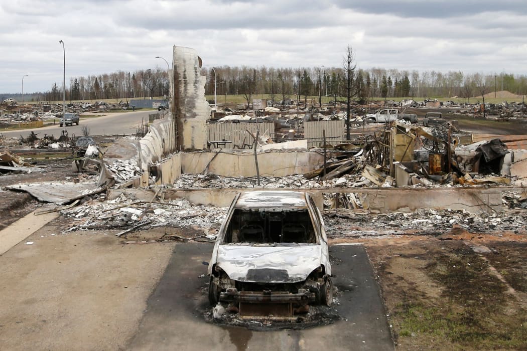 A charred vehicle and home are pictured in the Beacon Hill neighbourhood of Fort McMurray.