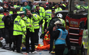 Members of the emergency services treat members of the public inside a Police cordon at the scene of an incident, on the sidelines of an open-top bus victory parade for Liverpool's Premier League title win.