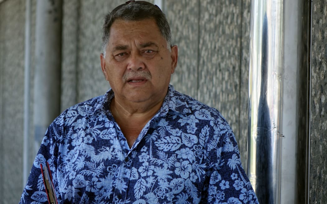 Fiji Architect John Grey in blue tropical shirt with plans under arm