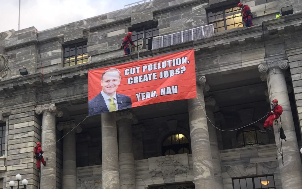 Four protesters scaled the building, placing solar panels on a ledge and unfurling a banner.