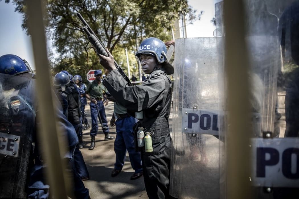 Zimbabwean anti riot police officers stand guard at gate of Rainbow Towers where the election's results were announced.