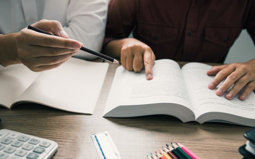 Teenager studying at desk and doing homeworks