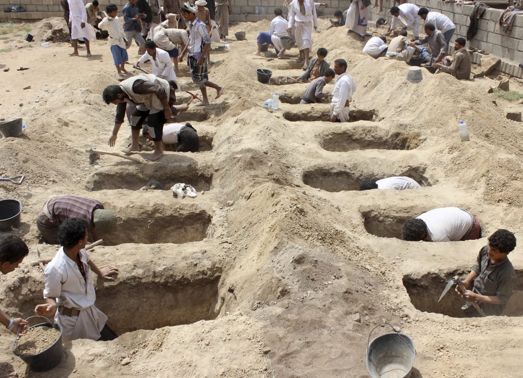 Yemenis dig graves for children, who where killed when their bus was hit during a Saudi-led coalition air strike, that targeted the Dahyan market the previous day in the Huthi rebels' stronghold province of Saada.