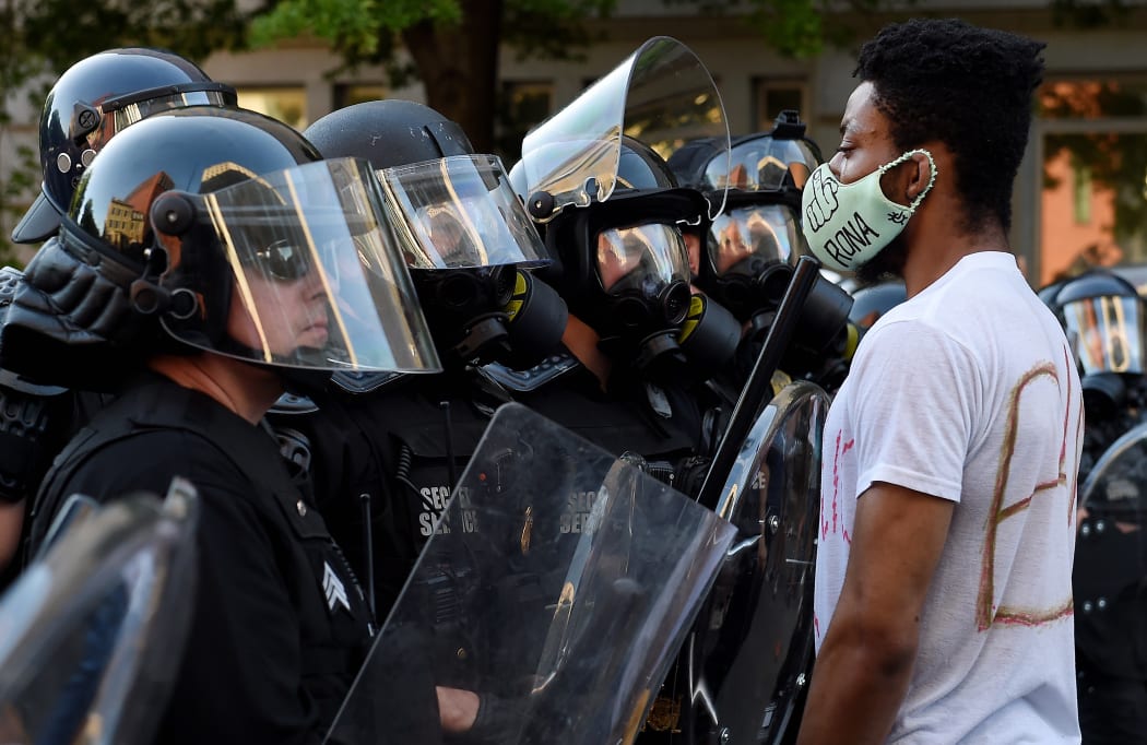 A row of police officers face off with demonstrators outside the White House to protest the death of George Floyd, who died in police custody.