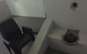 A basic toilet and plastic chair inside a cell in the isolation wing of the Don Dale Youth Detention Centre.