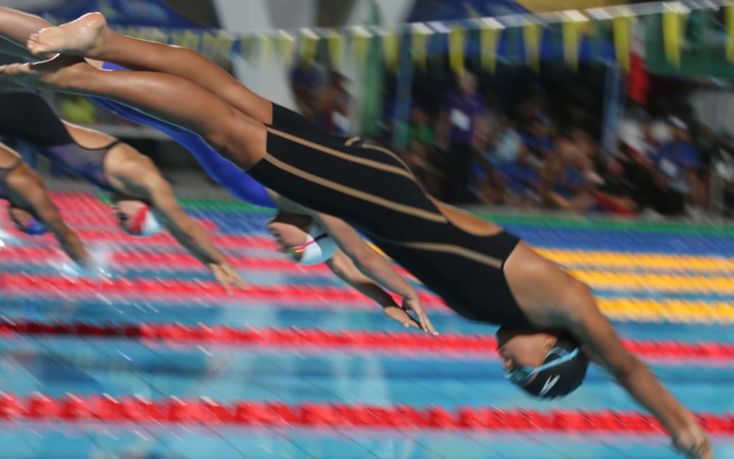 The first swimming finals of the Pacific Games drew a boisterous crowd. In this womens 100m butterfly Olivia Borg won Samoa's first gold medal.