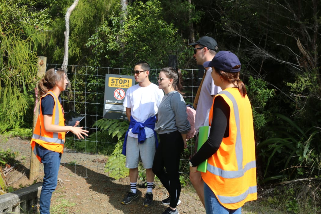 Auckland Council officers talk to trampers in the Waitākere Ranges.