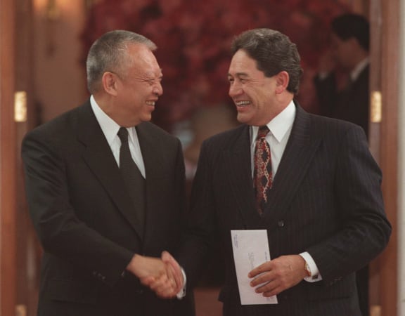 Hong Kong Chief Executive Tung Chee-hwa, left, and former New Zealand Treasurer Winston Peters shake hands during their meeting at the Government House in Hong Kong, a day after the handover on 2 July 1997.