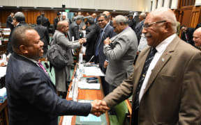 Fiji's leader of opposition Inia Seruiratu, left, and Prime Minister Sitiveni Rabuka shake hands after the Budget is passed on Thursday, 13 July 2023.