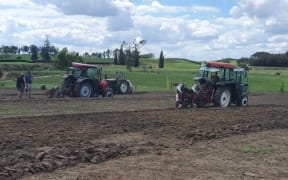 Two tractors ploughing.