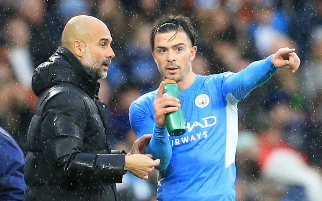 Manchester City manager Pep Guardiola  gives instructions to Jack Grealish