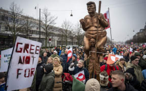 COPENHAGEN 2026-01-17
A statue of Trump, Greenlandic and Danish flags and placards as protesters gathered outside the US embassy in Copenhagen during a demonstration January 17, 2025 under the slogans "Hands off Greenland" and "Grønland for Grønlændere". 
Photo: Johan Nilsson / TT / Code 50090 (Photo by JOHAN NILSSON / TT News Agency via AFP)