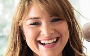 This is a headshoot of Rachael. She is smiling towards the camera. Her blonde hair falls around her face, framing her smile.