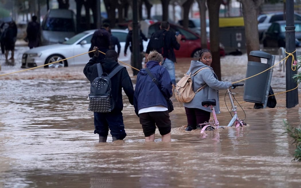 People walk through flooded streets in Valencia.