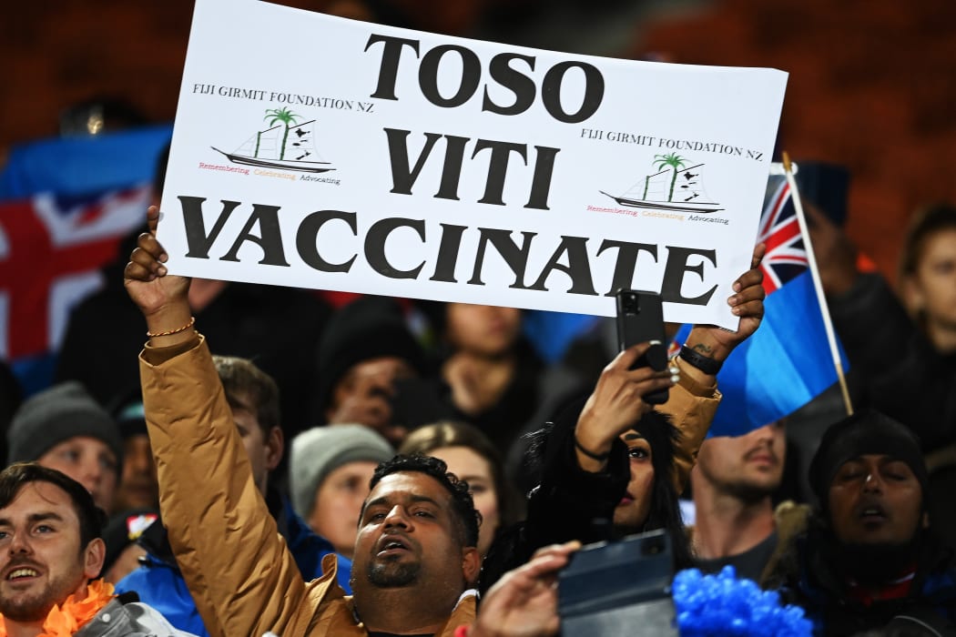Vaccinate Fiji signs held by fans.