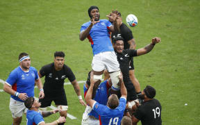 Namibia's lock Tjiuee Uanivi (C) jumps for the ball in a line out  during the match between New Zealand and Namibia.