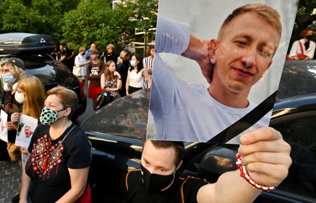 A picture of Vitaly Shishov is held by an activist as he takes part in a rally outside the Belarus embassy in Kiev on August 3, 2021.