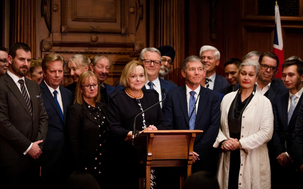 National Party leader Judith Collins addresses media with support from party members following the emergency caucus meeting on 14 July.