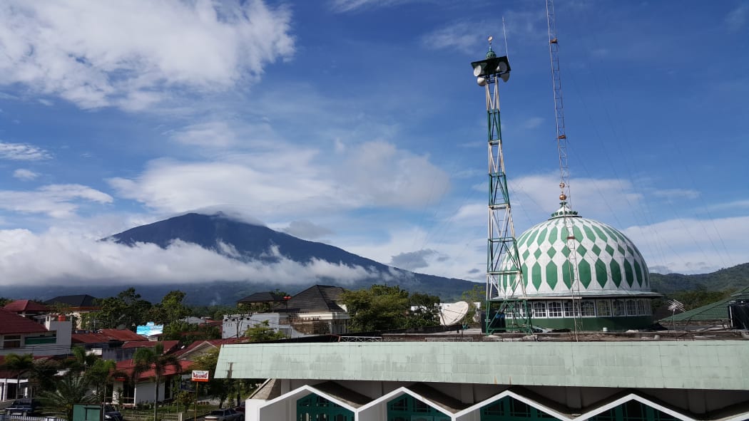 Mount Singgalang volcano with a mosque in Bukitinggi