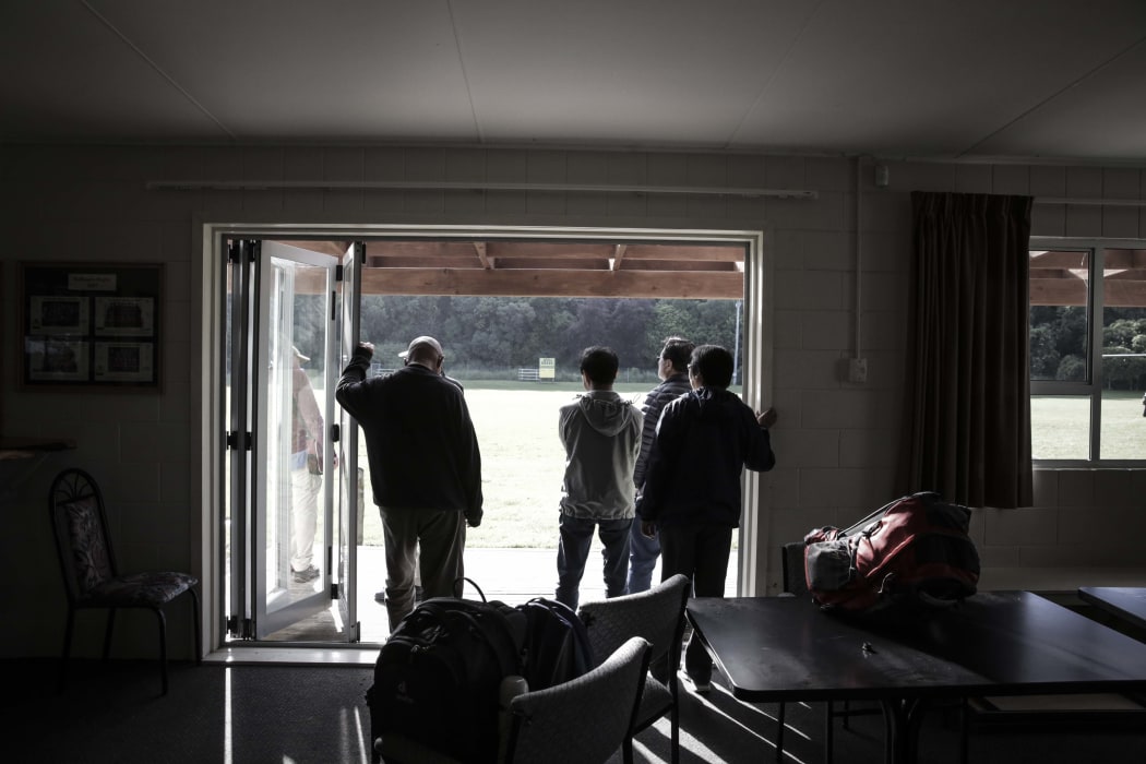 People wait at the rugby club to be airlifted out.