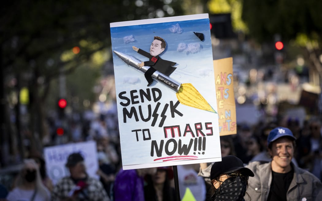 A protester holds a sign as they march during the nationwide 'Hands Off!' protest against Trump and his advisor, Tesla CEO Elon Musk, in downtown Los Angeles.