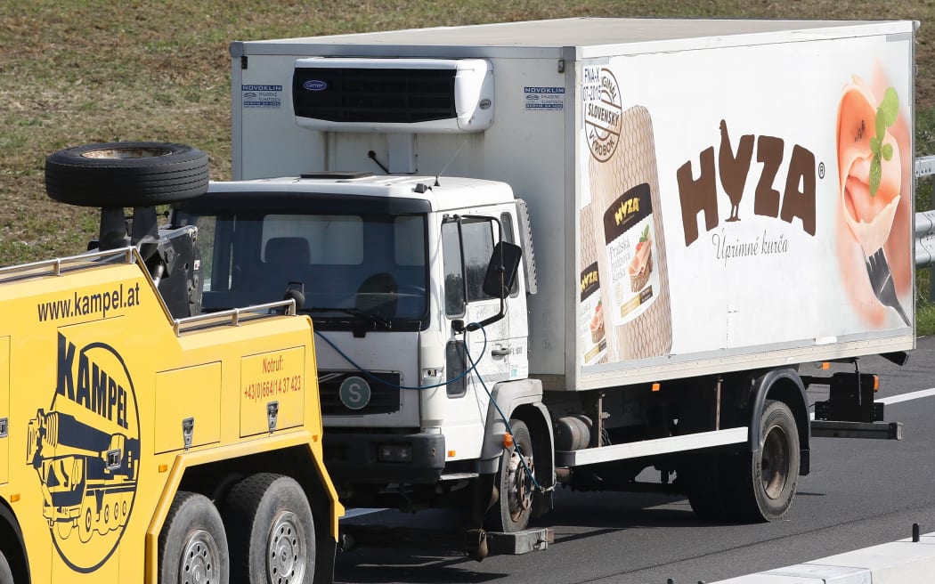 The refrigerated truck being towed from the site.