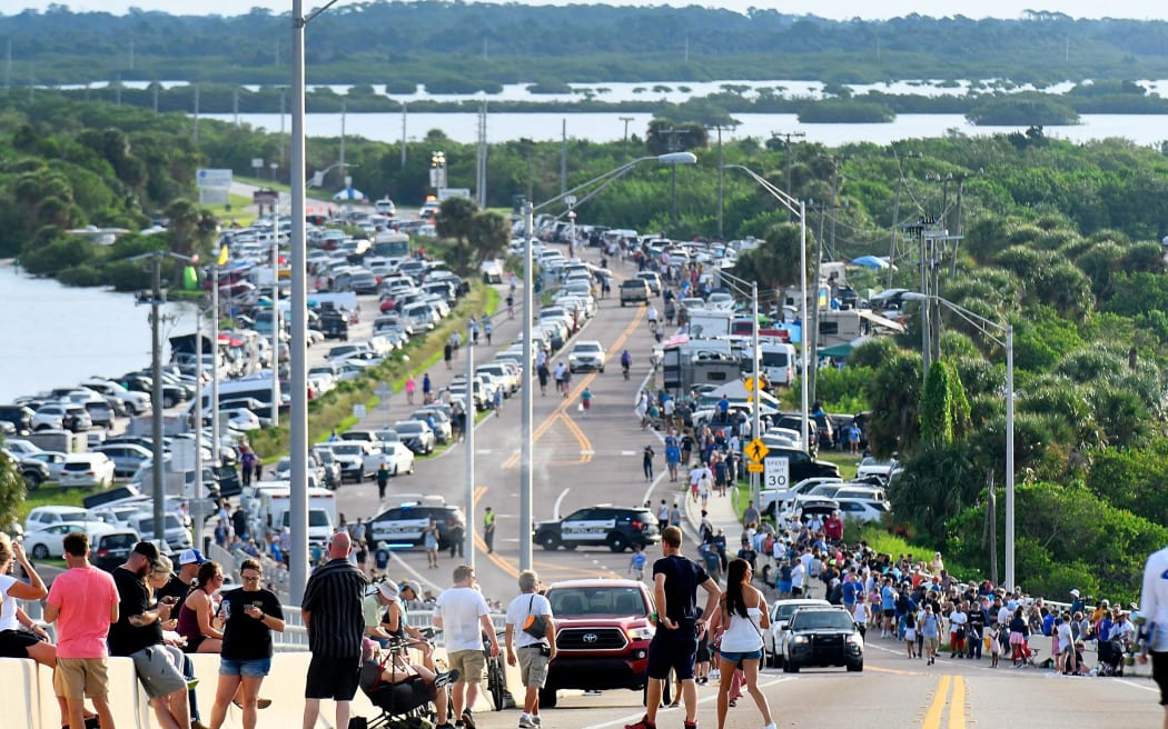 People waiting for the Artemis I rocket to be launched from the Kennedy Space Center on 29 August, 2022 in Cape Canaveral, as seen from the A. Max Brewer Bridge in Titusville, Florida. The launch was scrubbed after an issue was found on one of the rocket's four engines.