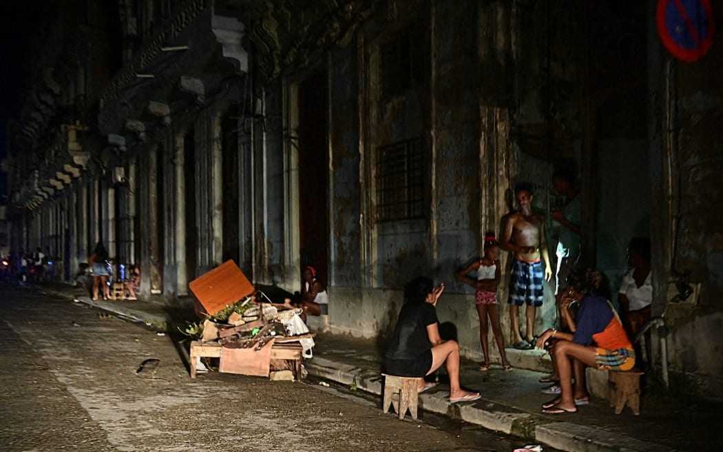 Cubans chat at night during a nationwide blackout caused by a grid failure, 18 October, 2024.
