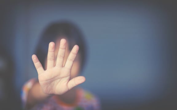 child with hand on window