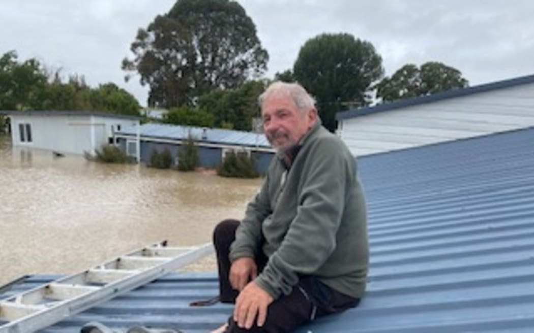 Mike Brown waits to be rescued from his roof in Pakowhai