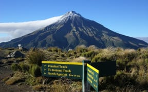 Signage for the Pouakai Circuit in the foreground of Mt Taranaki