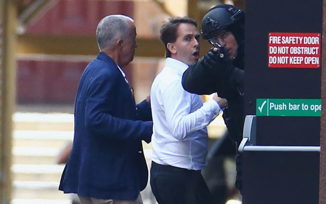 Two hostages run to safety from the Lindt Cafe.