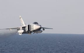 A Russian Sukhoi Su-24 attack aircraft fly over the USS Donald Cook (DDG 75),an Arleigh Burke-class guided-missile destroyer, operating in the Baltic Sea April 12, 2016. A United States Navy Destroyer operating in international waters in the Baltic Sea experienced several close interactions by Russian aircraft on April 11 and 12. USS Donald Cook (DDG 75) encountered multiple, aggressive flight maneuvers by Russian aircraft that were performed within close proximity of the ship. On April 11, Donald Cook was conducting deck landing drills with an Allied military helicopter when two Russian SU-24 jets made numerous, close-range and low altitude passes at approximately 3 p.m. local. One of the passes, which occurred while the Allied helicopter was refueling on the deck of Donald Cook, was deemed unsafe by the ship’s commanding officer. As a safety precaution, flight operations were suspended until the SU-24s departed the area. (Photo by Handout / US NAVY 6TH FLEET / AFP) / RESTRICTED TO EDITORIAL USE -...