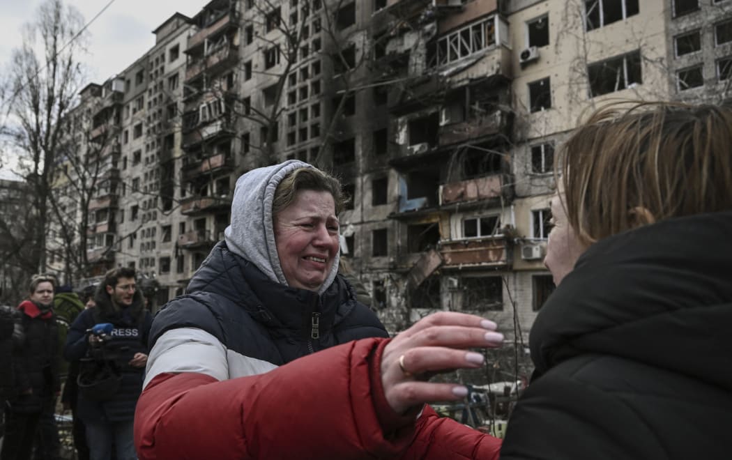 A woman reacts as she stands outside destroyed apartment blocks following shelling in the northwestern Obolon district of Kyiv on March 14, 2022.