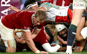 First Nations & Pasifika XV' Seru Uru (R) reacts after scoring a try as British and Irish Lions’ Jac Morgan (L) holds the ball during the rugby tour match against at Docklands Stadium in Melbourne on July 22, 2025. (Photo by WILLIAM WEST / AFP) / -- IMAGE RESTRICTED TO EDITORIAL USE - STRICTLY NO COMMERCIAL USE --