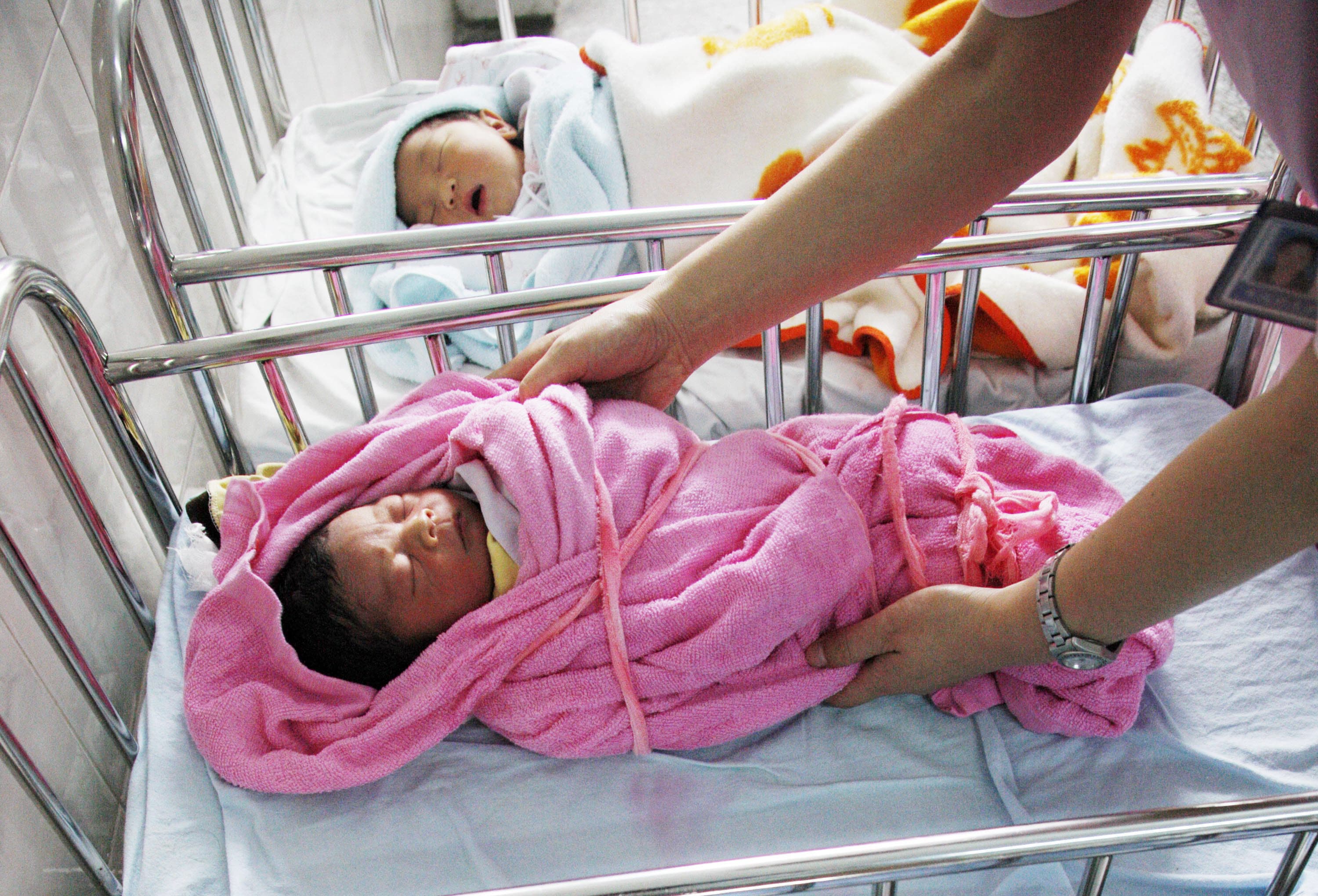 This file picture taken on July 5, 2010 shows a Chinese nurse attending to several newly-born babies at a hospital in Huaibei, east China's Anhui province.