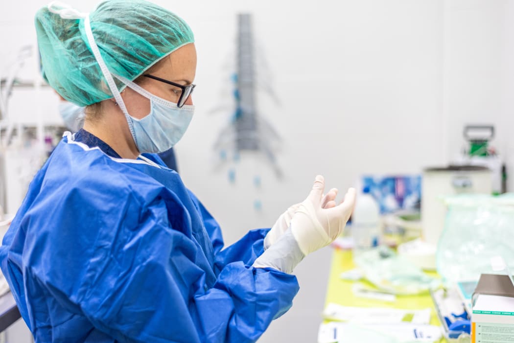 Female nurse puts on protective gloves. Personal protective equipment in the fight against Coronavirus disease .