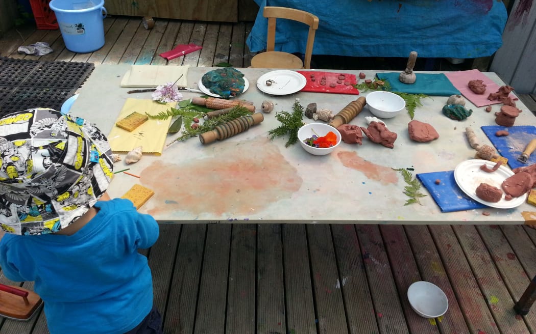 A child plays at the natural collage table at Glenn Innes Playcentre.