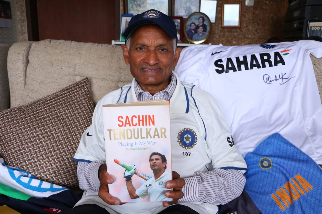 Nanubhai Ranchhod delightedly holds his prized Sachin Tendulkar book.