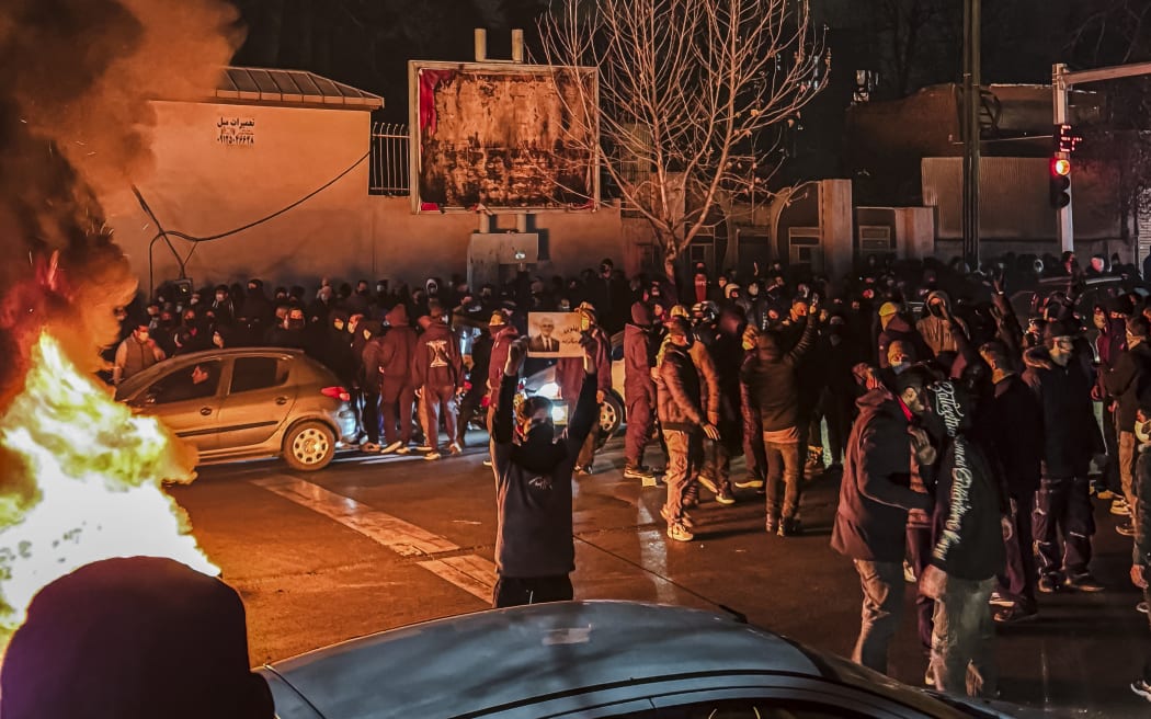 Iranians gather while blocking a street during a protest in Tehran, Iran on January 9, 2026. The nationwide protests started in Tehran's Grand Bazaar against the failing economic policies in late December, which spread to universities and other cities, and included economic slogans, to political and anti-government ones. (Photo by MAHSA / Middle East Images via AFP)