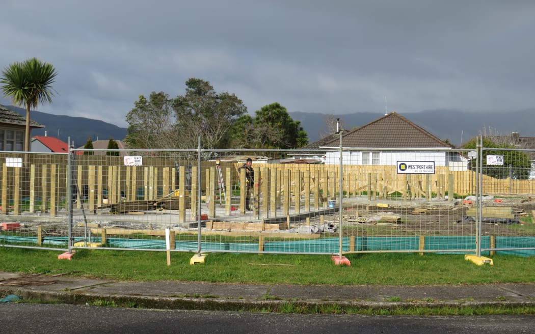 Piles 1.5m high are nearly as high as a worker on this site for two new Kāinga Ora homes in Westport. The home that used to occupy this site was demolished after being inundated in the 2021 floods. The new floor heights are a council requirement