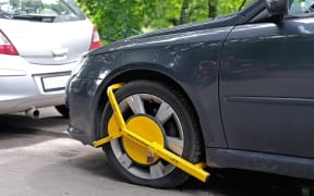 Wheel clamp mounted on parked car