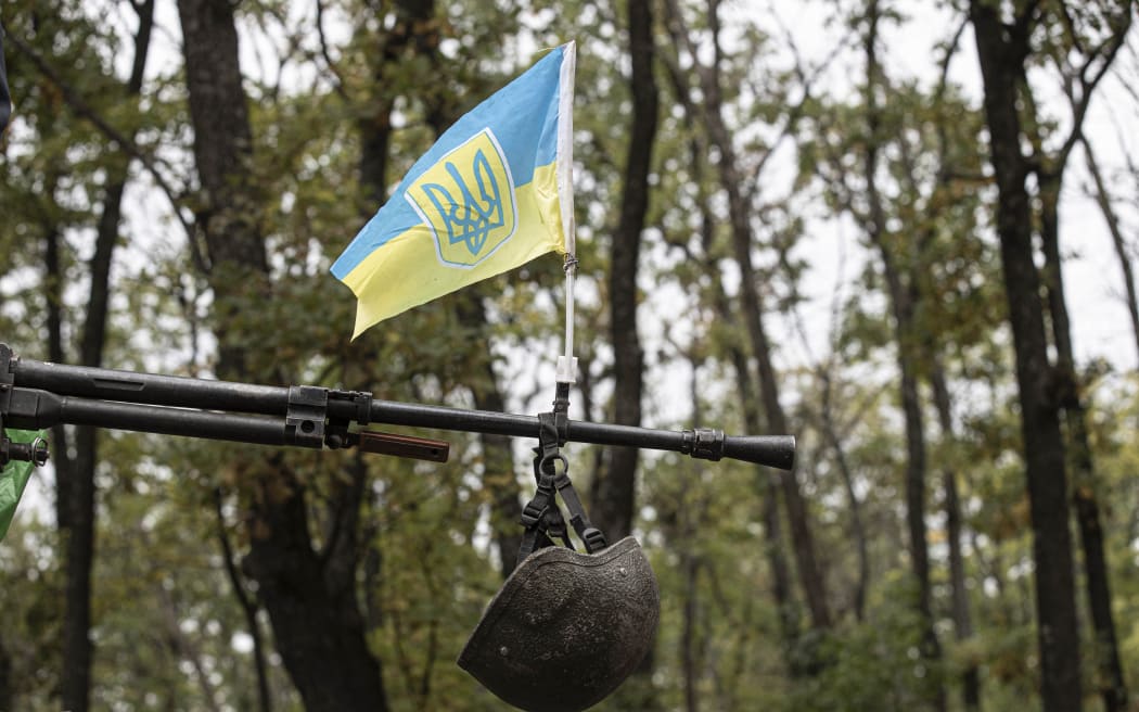 A helmet is hung on the barrel of a rifle in Kupiansk, in Ukraine's Kharkiv province, after the city was regained from Russian forces on 20 September, 2022.