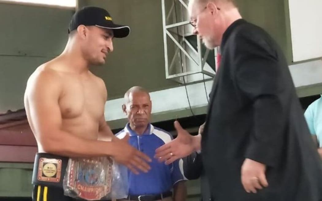 Ezatullah Kakar is presented with his title belt.