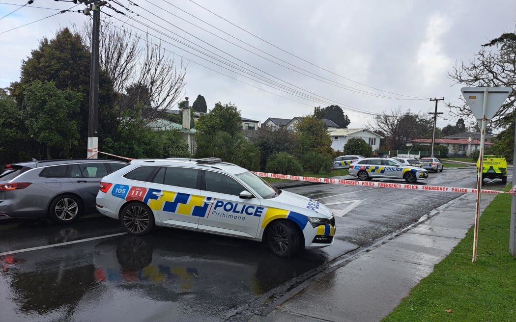 Police cars and cordons are seen at the end of Graham Avenue in Te Atatū. At least eight police, and two St John's vehicles are in attendance.