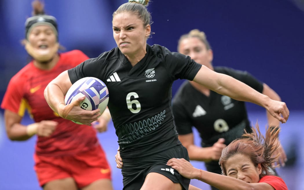New Zealand's Michaela Blyde is chased by China's Dou Xinrong (R) during the women's pool A rugby sevens match between New Zealand and China during the Paris 2024 Olympic Games at the Stade de France in Saint-Denis on July 28, 2024. (Photo by CARL DE SOUZA / AFP)