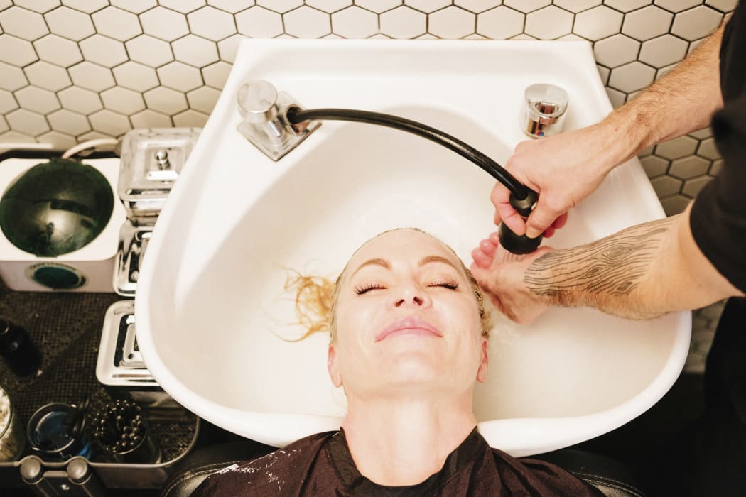 [Utah, USA] A female client at a hair salon, having her hair rinsed in a basin. (Photo by Mint Images / Mint Images / Mint Images via AFP)