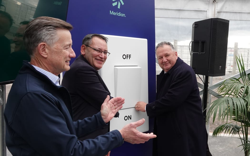 From left, Meridian chairman Mark Verbiest and Ministers Shane Reti and Shane Jones flick a giant switch to symbolically turn on the giant battery, on 23 May 2025.