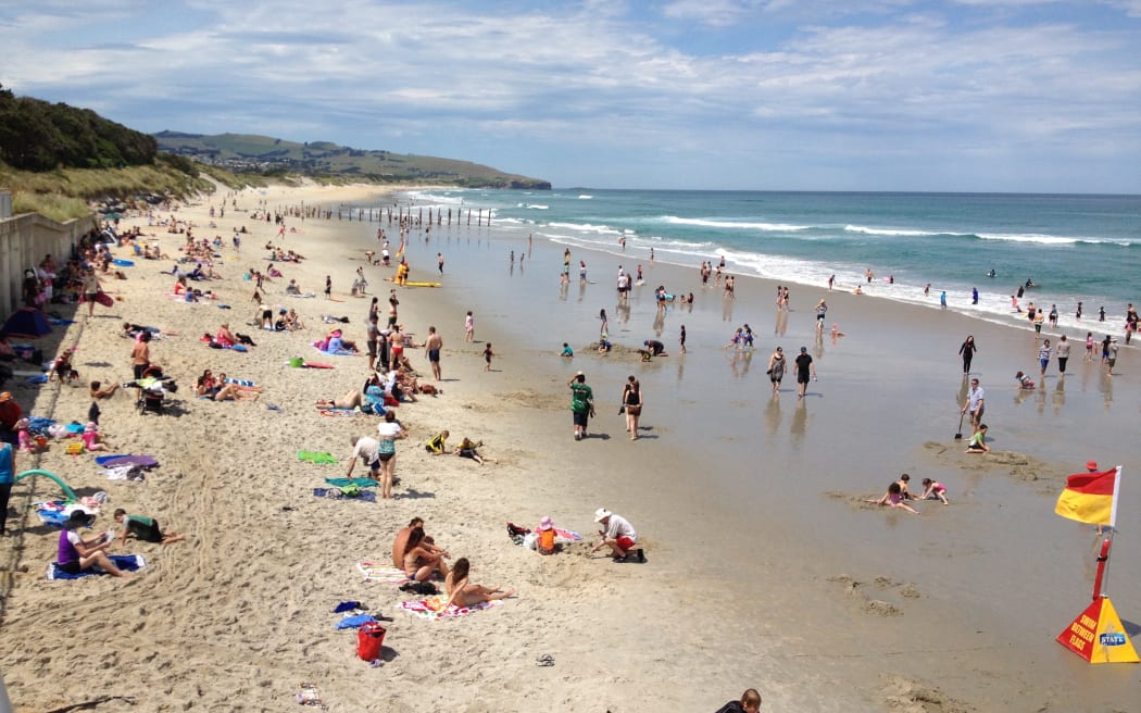 People flock to Dunedin's St Clair Beach as temperatures pass 30 degrees Celsius