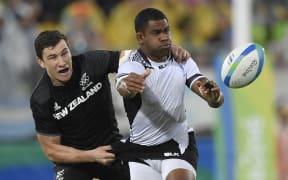 New Zealand's Sam Dickson, left, tackles Fiji's Vatemo Ravouvou in the men’s rugby sevens quarter-final match between Fiji and New Zealand at the Rio Olympics.